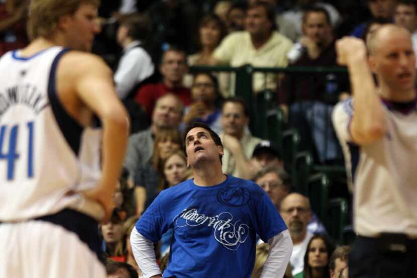 Dallas Mavericks owner Mark Cuban watches the replay on a foul called on Dirk Nowitzki (41)...