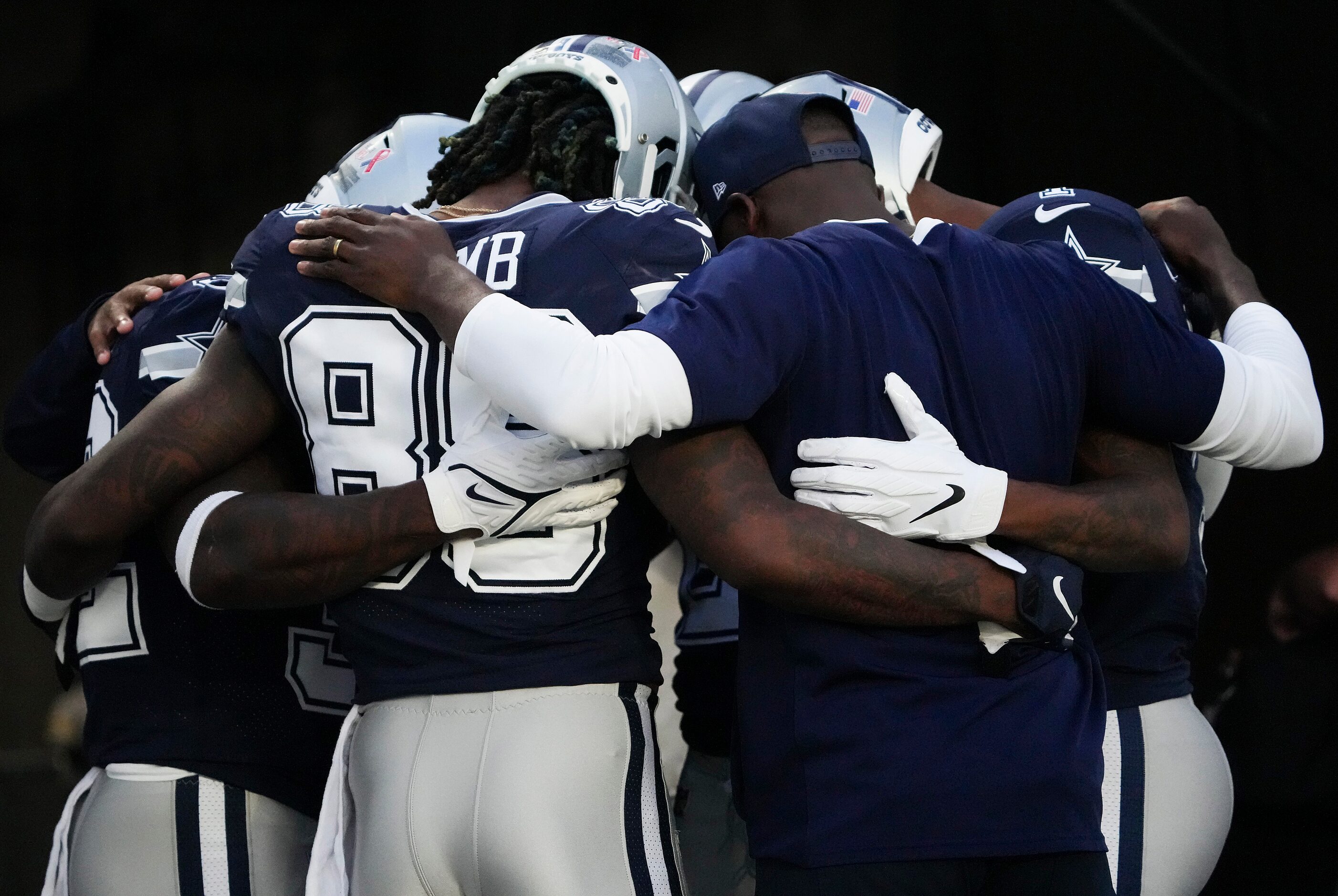 Dallas Cowboys wide receiver CeeDee Lamb joins teammates as they huddle before an NFL...