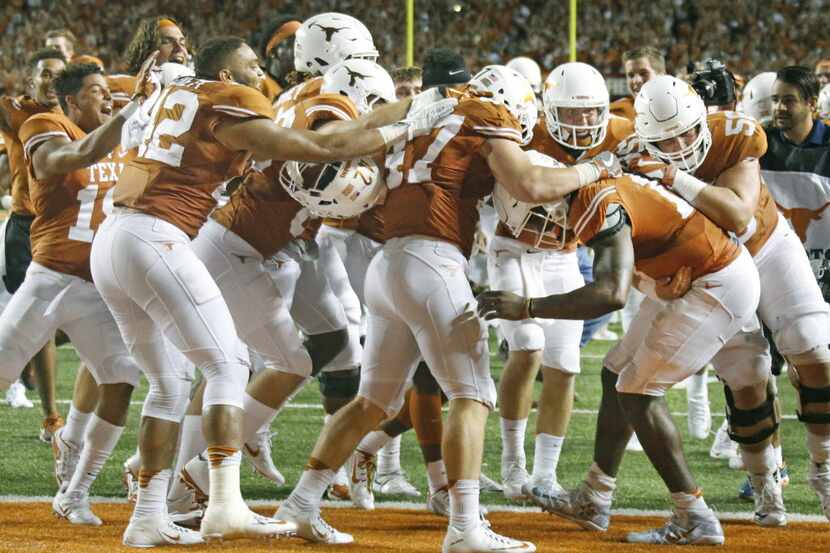 Teammates mob Texas quarterback Tyrone Swoopes after he scored the winning touchdown in the...