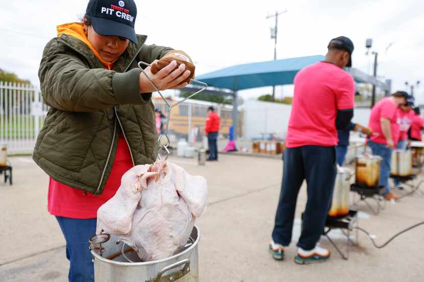 Volunteer Dominique Reeves of Dallas dips a turkey in a grill during the Annual Dallas...