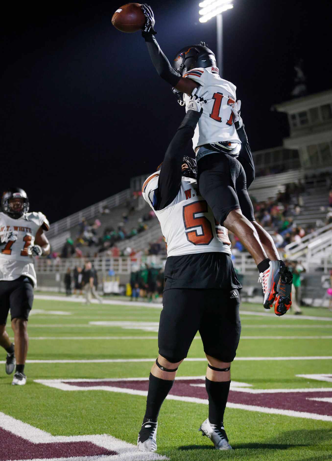 W.T. White wide receiver Bralon Beasley (17) is hoisted in the air by lineman Anthony Chibli...
