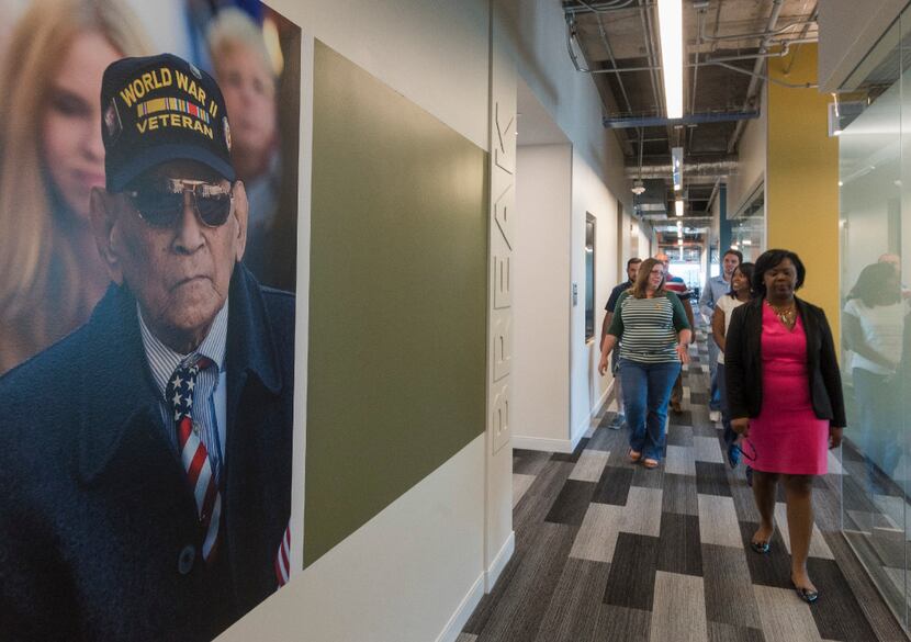 USAA workers walk down the hallway of the insurance company's office building in Plano. 