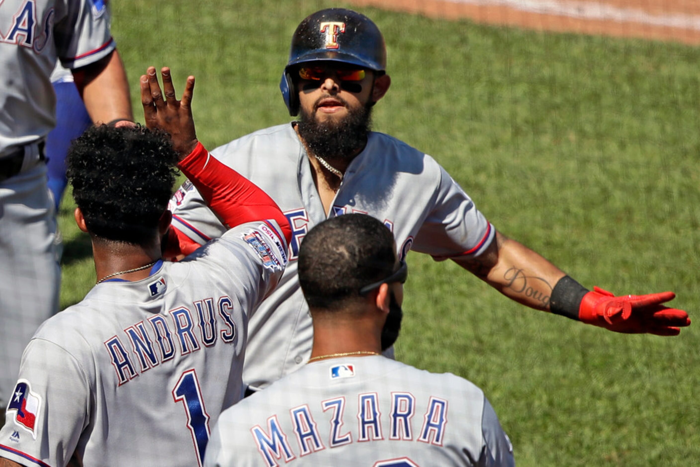 Texas Rangers' Rougned Odor, top center, celebrates as he returns to the dugout after...