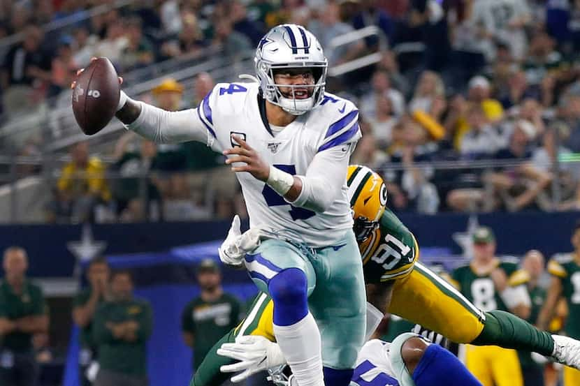 Dallas Cowboys quarterback Dak Prescott (4) eludes the Green Bay Packers defense during the...