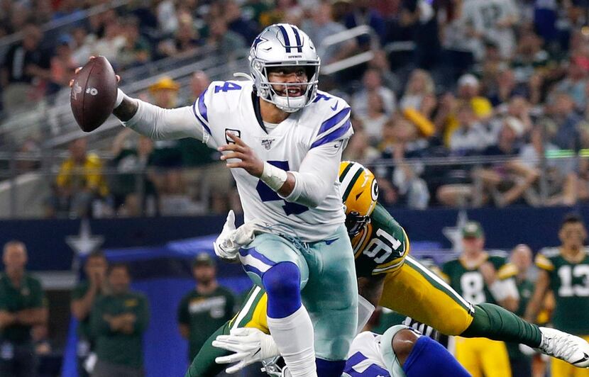 FILE — Dallas Cowboys quarterback Dak Prescott (4) eludes the Green Bay Packers defense...