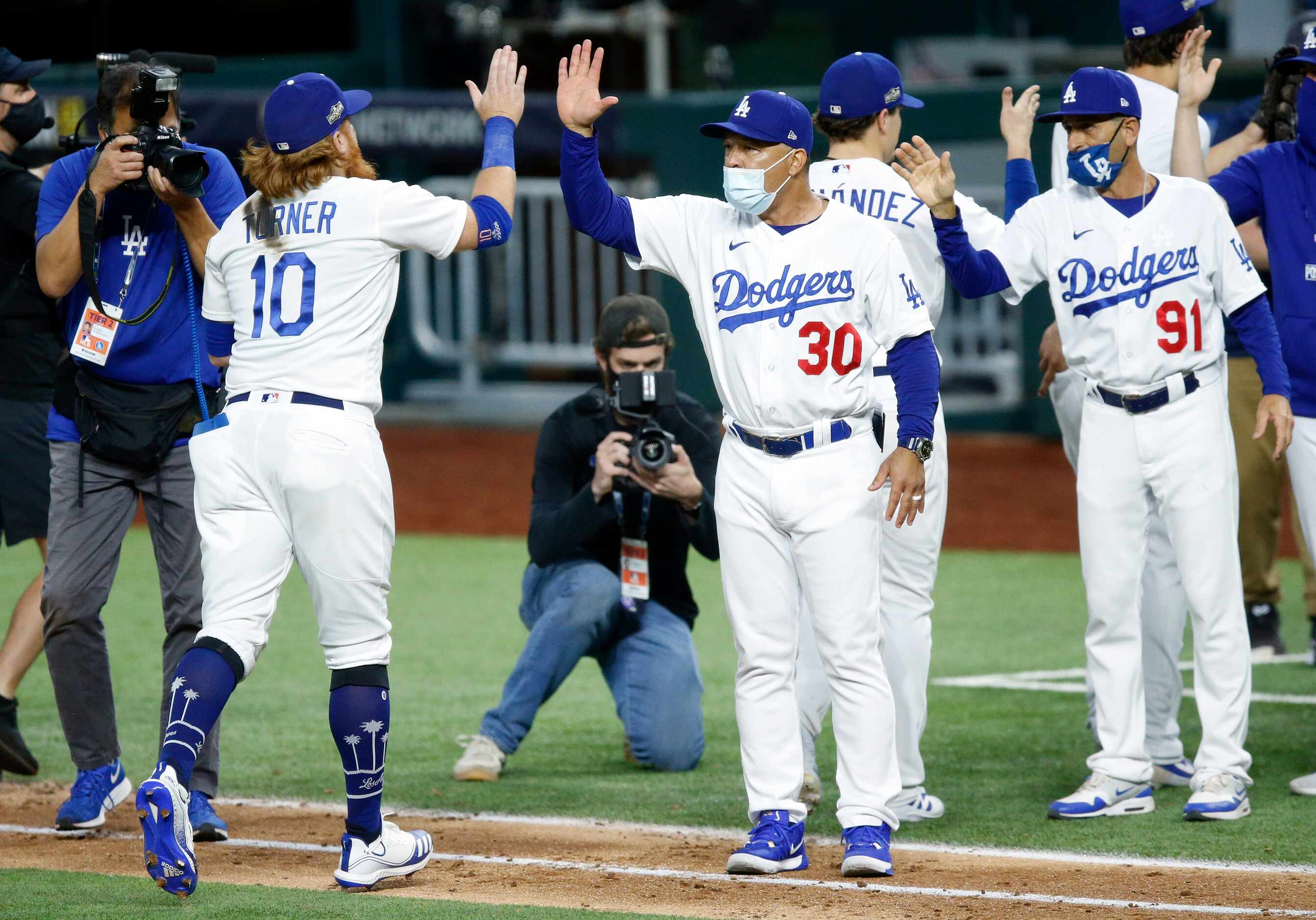 Los Angeles Dodgers manager Dave Roberts (30) congratulates Los Angeles Dodgers third...