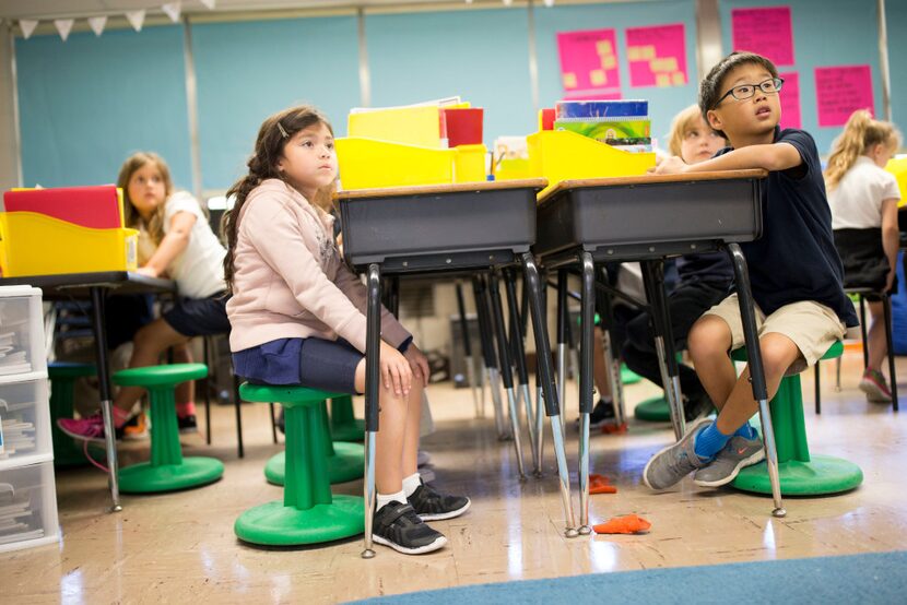 Leia Pena (left), 7, and Daniel Kang, 7 sit on wobble stools donated from Staples though...