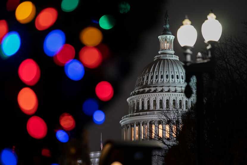 The Capitol is seen amid holiday lights Wednesday evening as the House of Representatives...