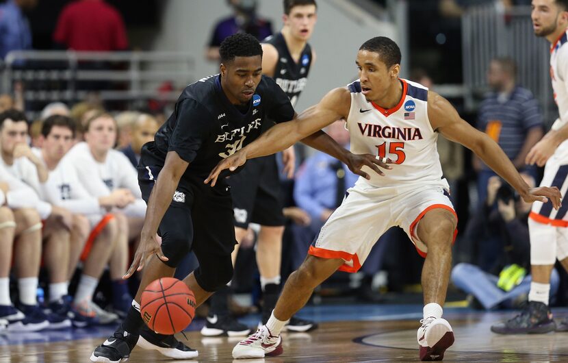 Kelan Martin #30 of the Butler Bulldogs drives against Malcolm Brogdon #15 of the Virginia...