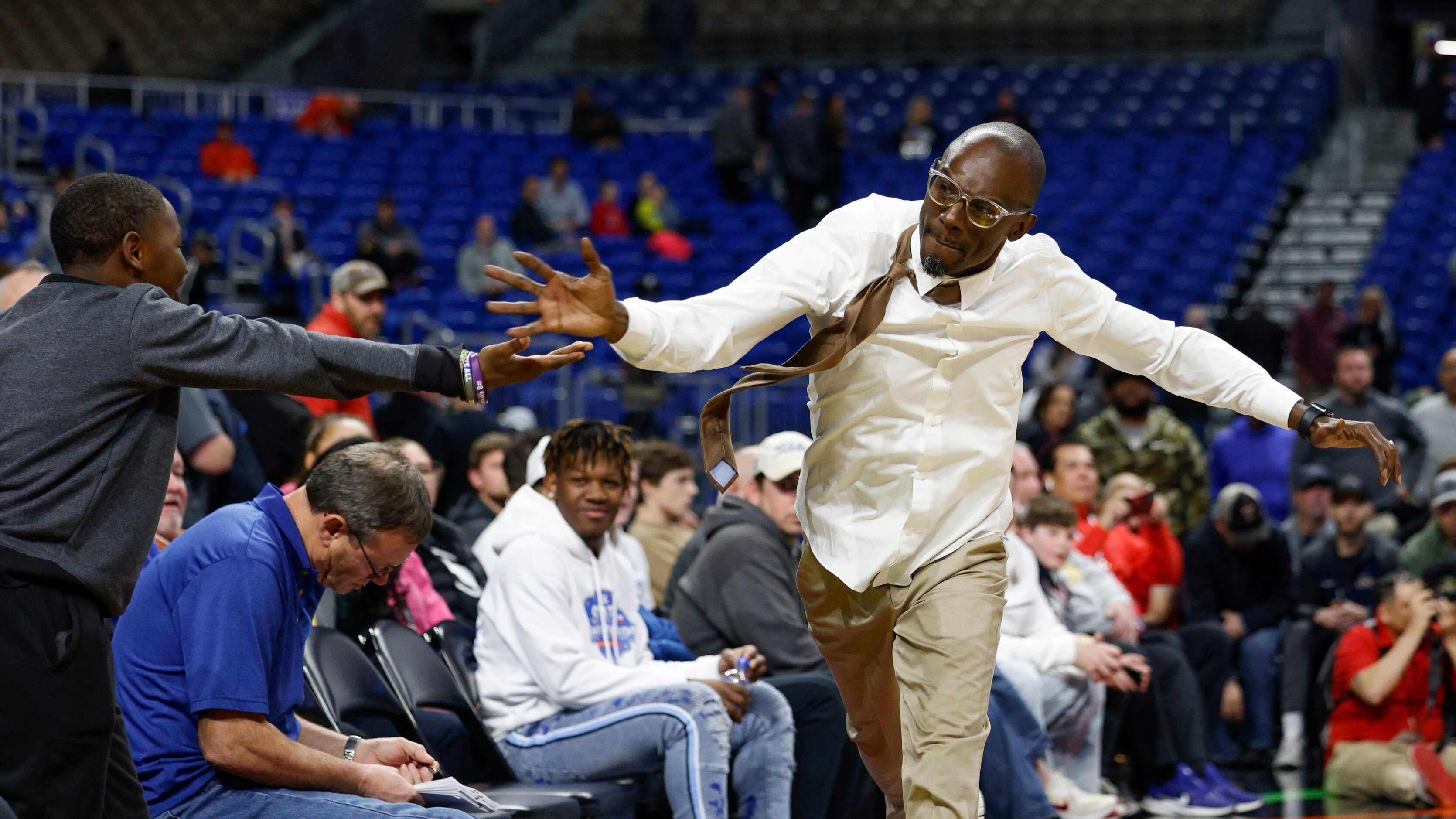 Madison head coach Damien Mobley high-fives a fan after winning the Class 3A state...