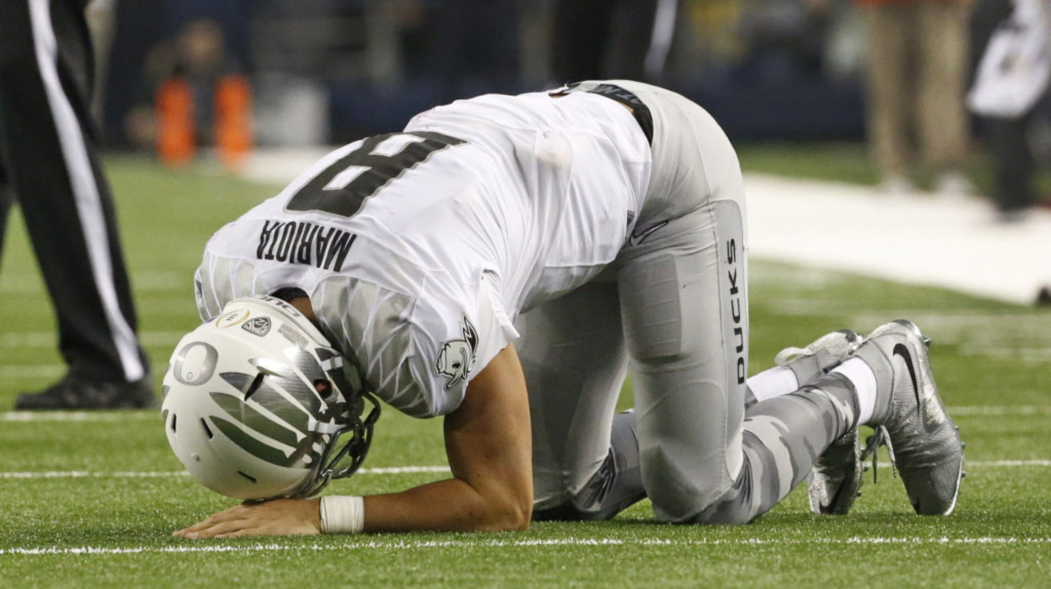 Oregon Ducks quarterback Marcus Mariota (8) remains on the turf after a hard hit in the...