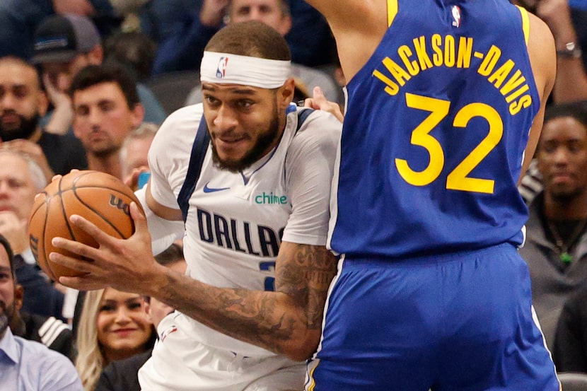 Dallas Mavericks center Daniel Gafford (21), left, looks to pass against Golden State...