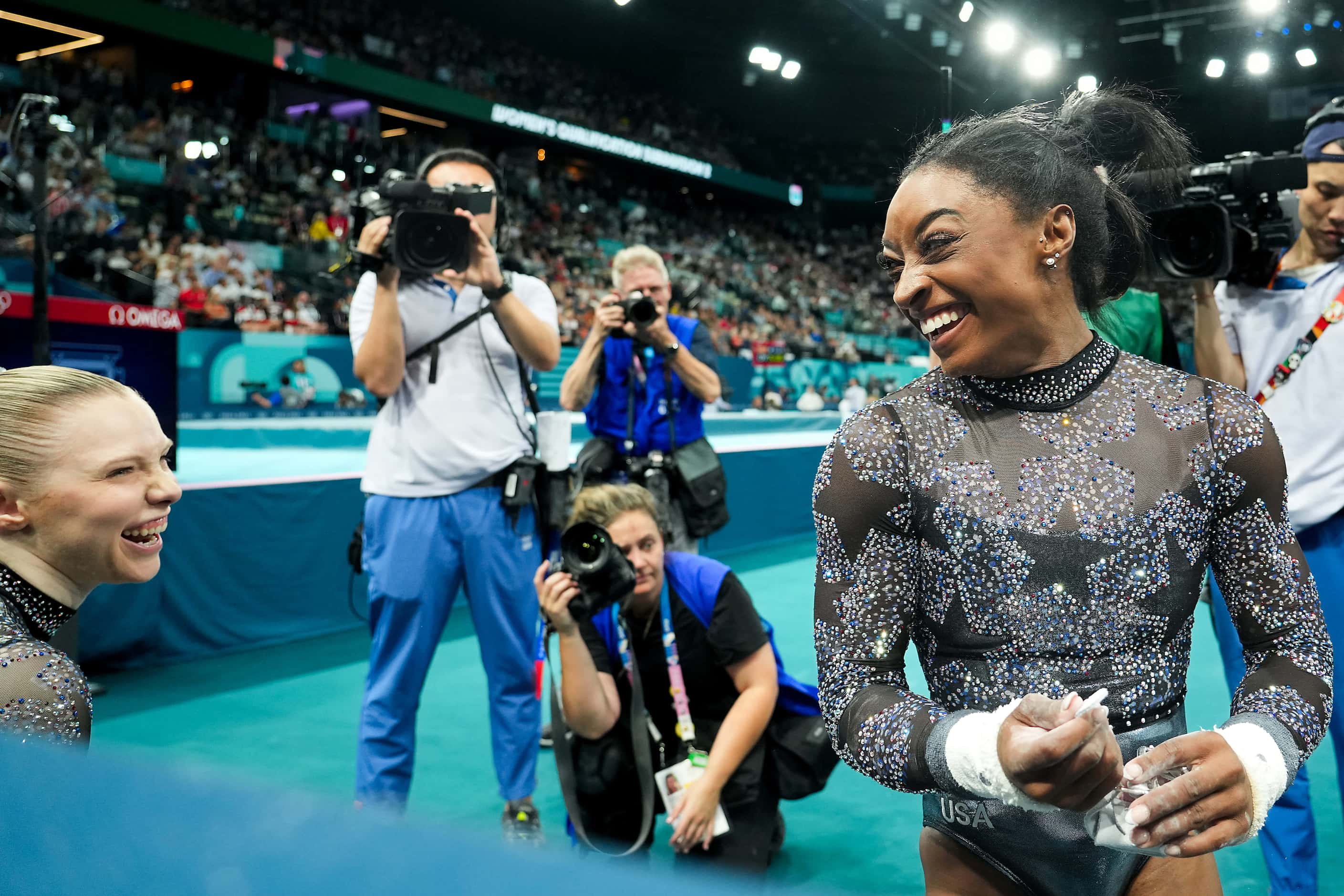 Simone Biles of the United States (right) laughs with teammate Jade Carey after competing on...