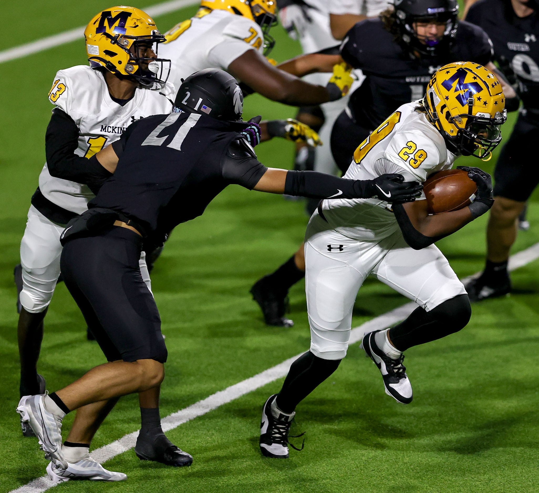 McKinney running back Makaden Frazier (29) breaks a tackle from Denton Guyer defensive back...