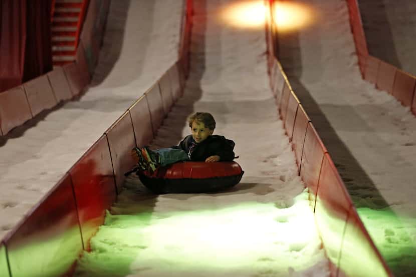 Hayden Atkinson, 4, of Houston, glides down on the ice slide.