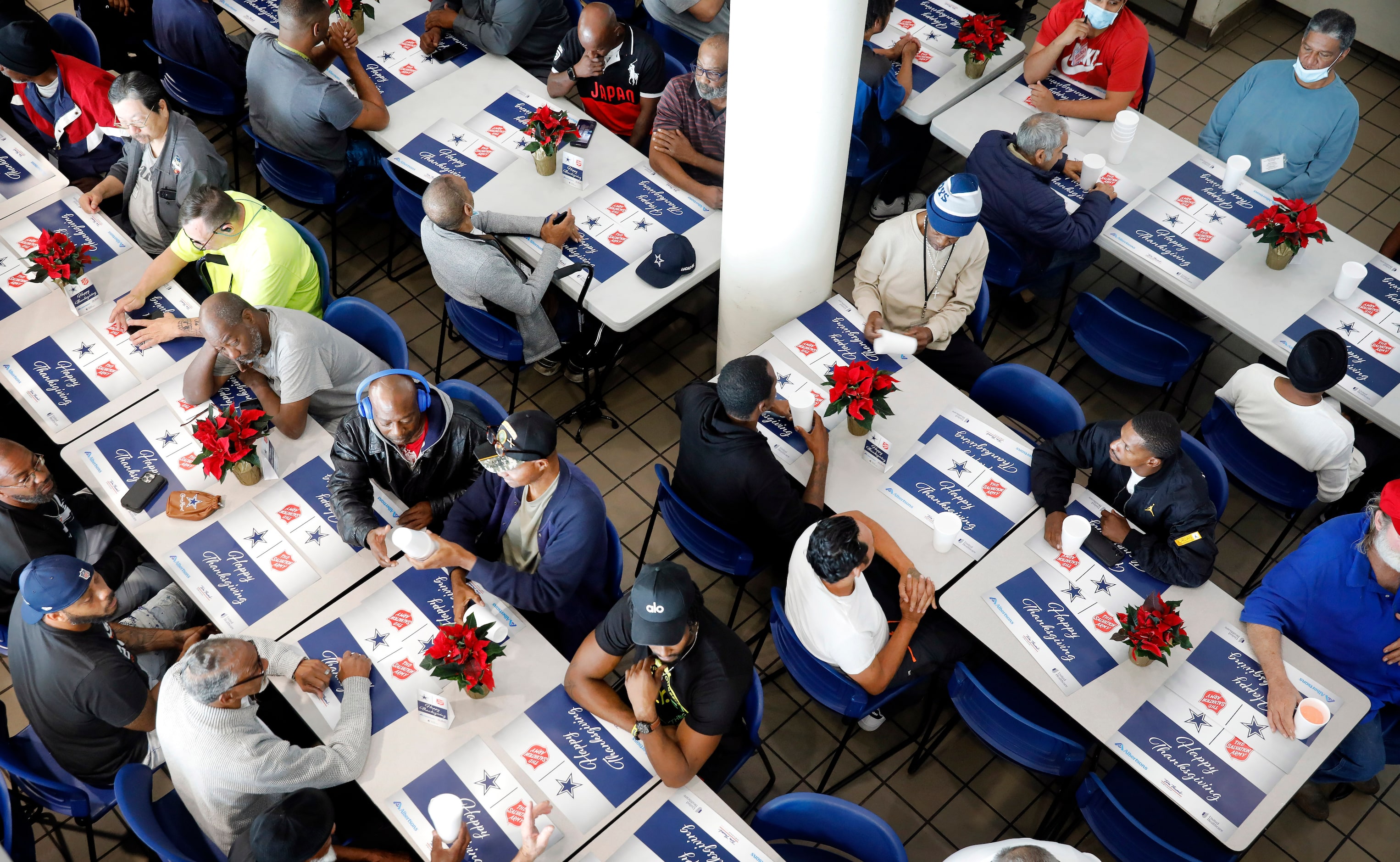 Clients wait to be served an “Early” Thanksgiving Day meal from veteran Dallas Cowboys...