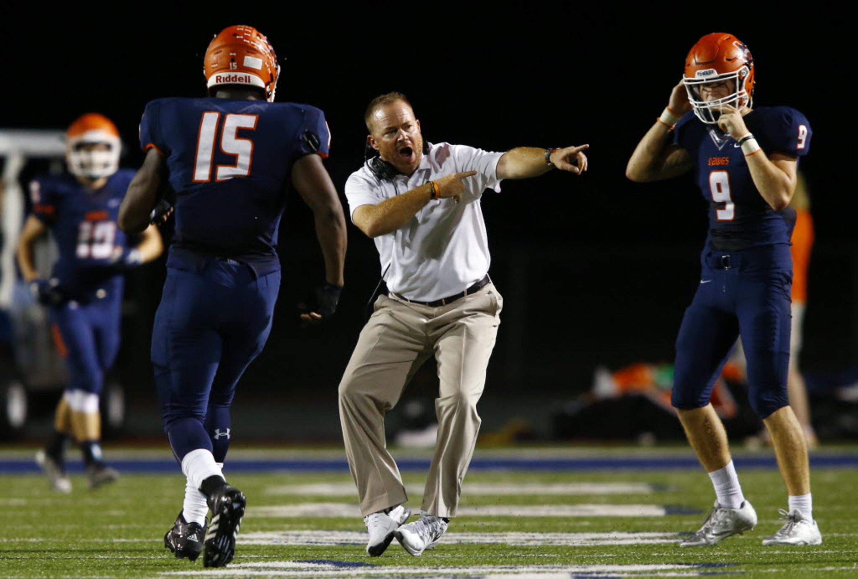 TXHSFB McKinney North head coach Mike Fecci tries to shepherd defensive lineman Justin...