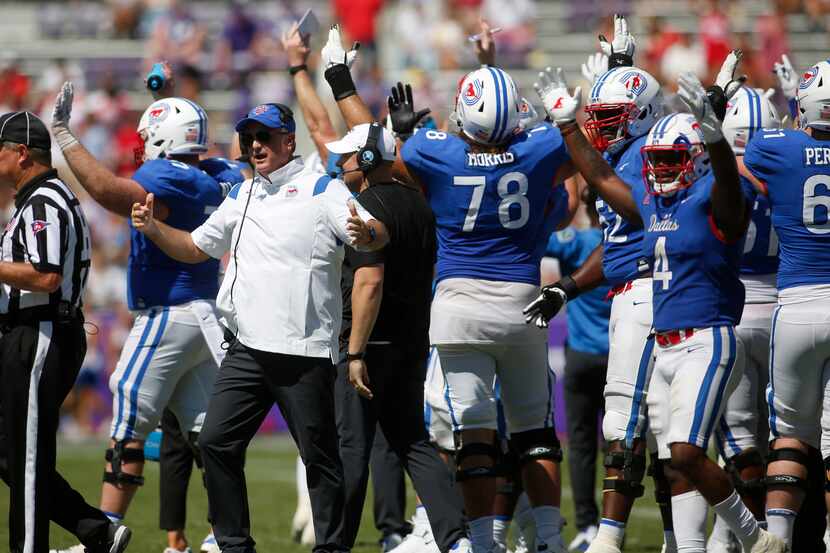 SMU coach Sonny Dykes leads his team's effort to question a call after the replay was shown...