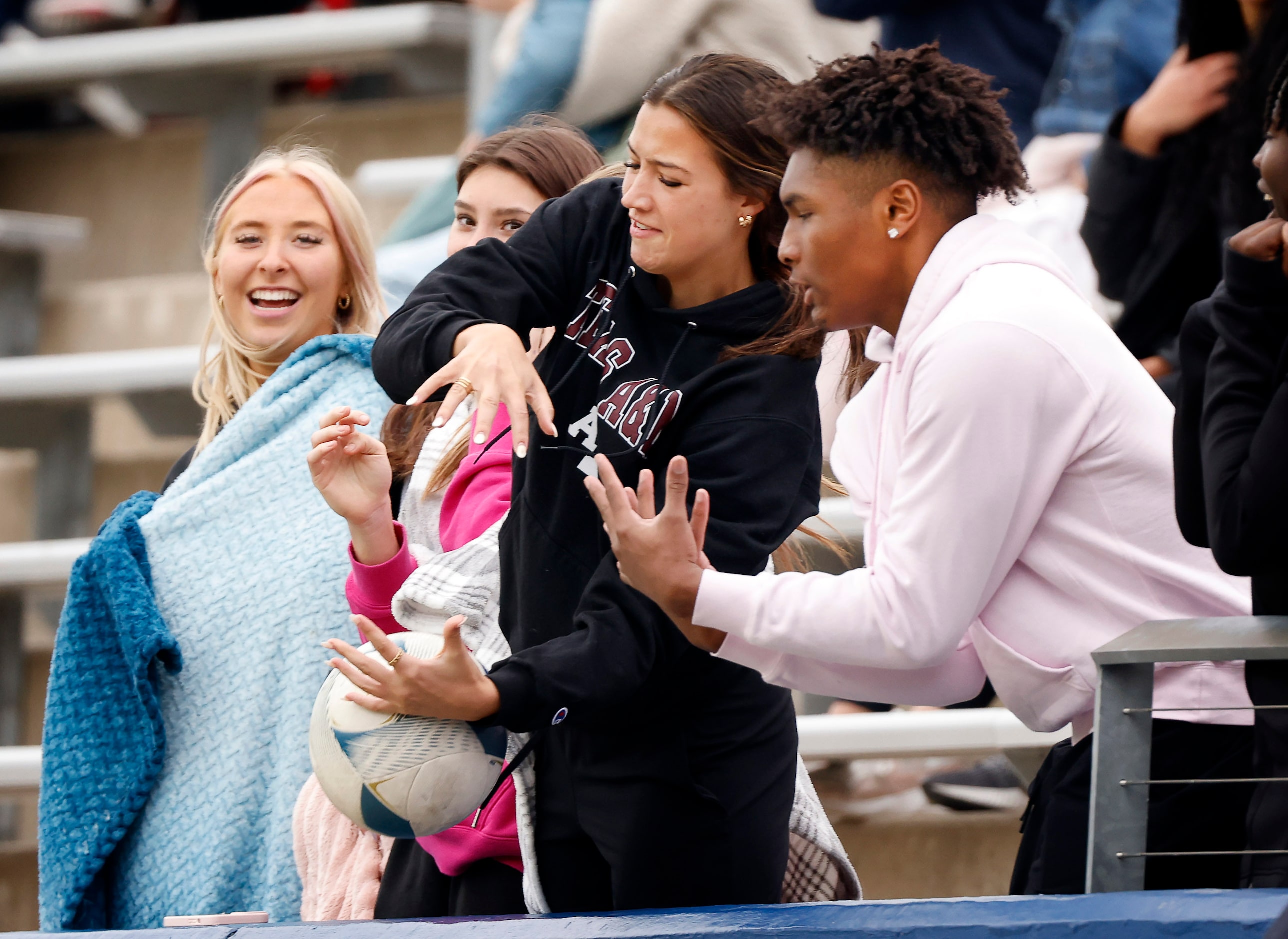 Flower Mound Marcus fans try to catch a ball kicked out of bounds during their Class 6A...