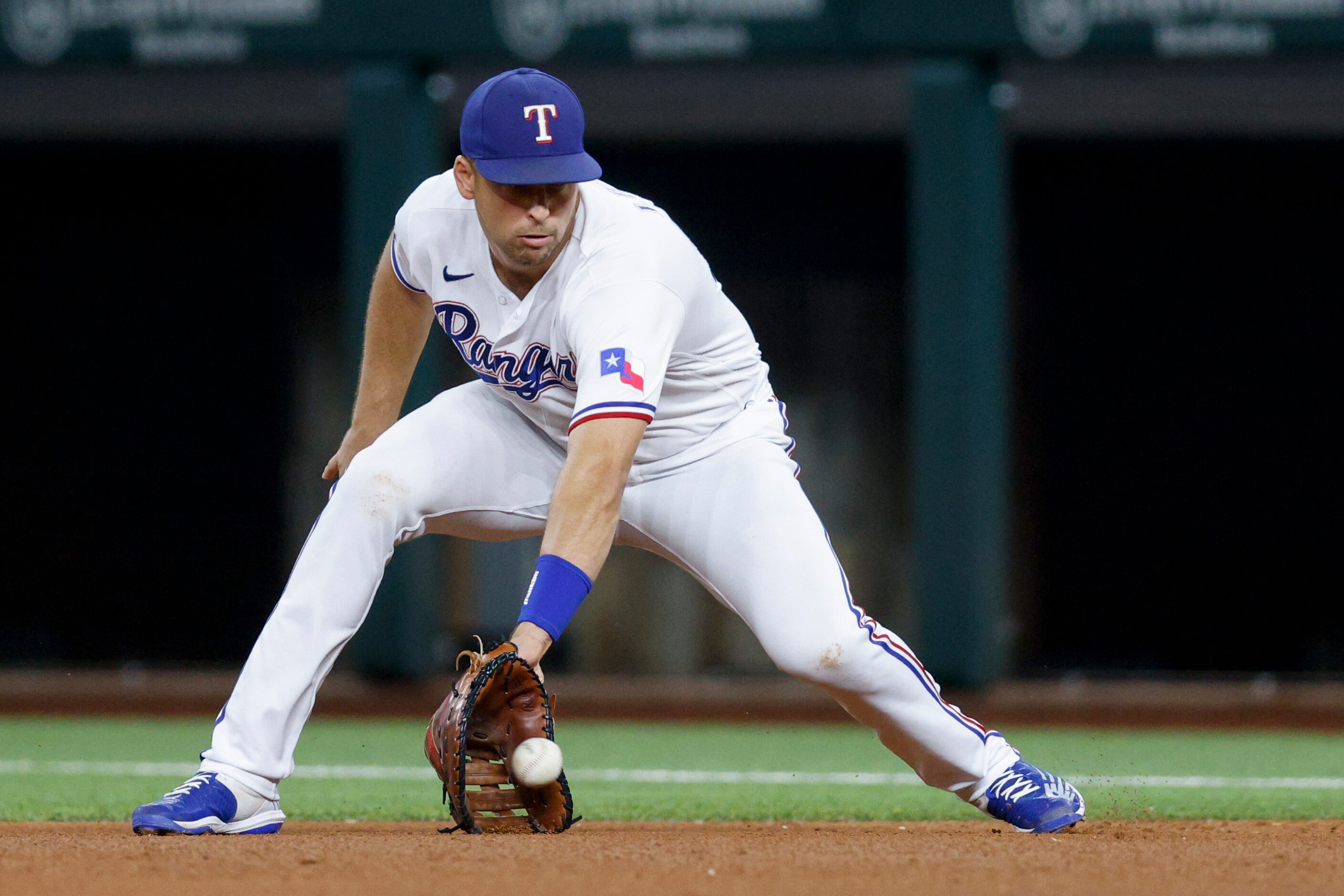 Texas Rangers first baseman Nathaniel Lowe (30) fields the ball before throwing to first...