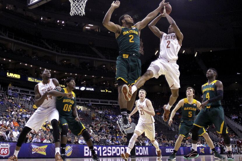 Baylor's Rico Gathers, left, blocks a shot by Texas' Demarcus Holland during the second half...