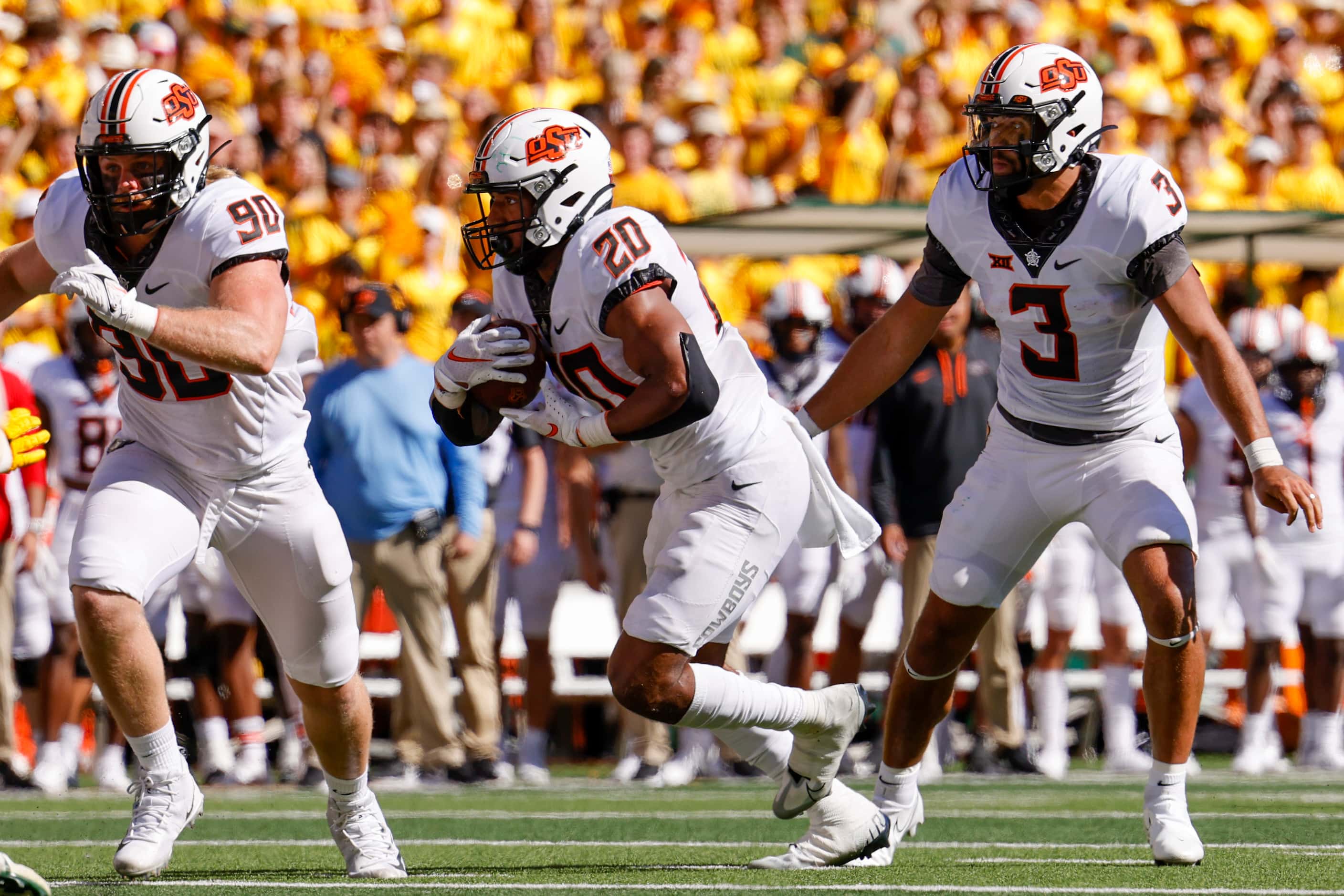Oklahoma State quarterback Spencer Sanders (3) hands the ball to running back Dominic...