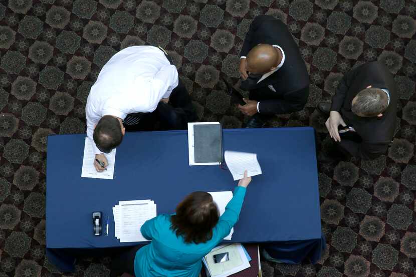 In this Wednesday, Jan. 22, 2014, file photo, job seekers sign in before meeting prospective...