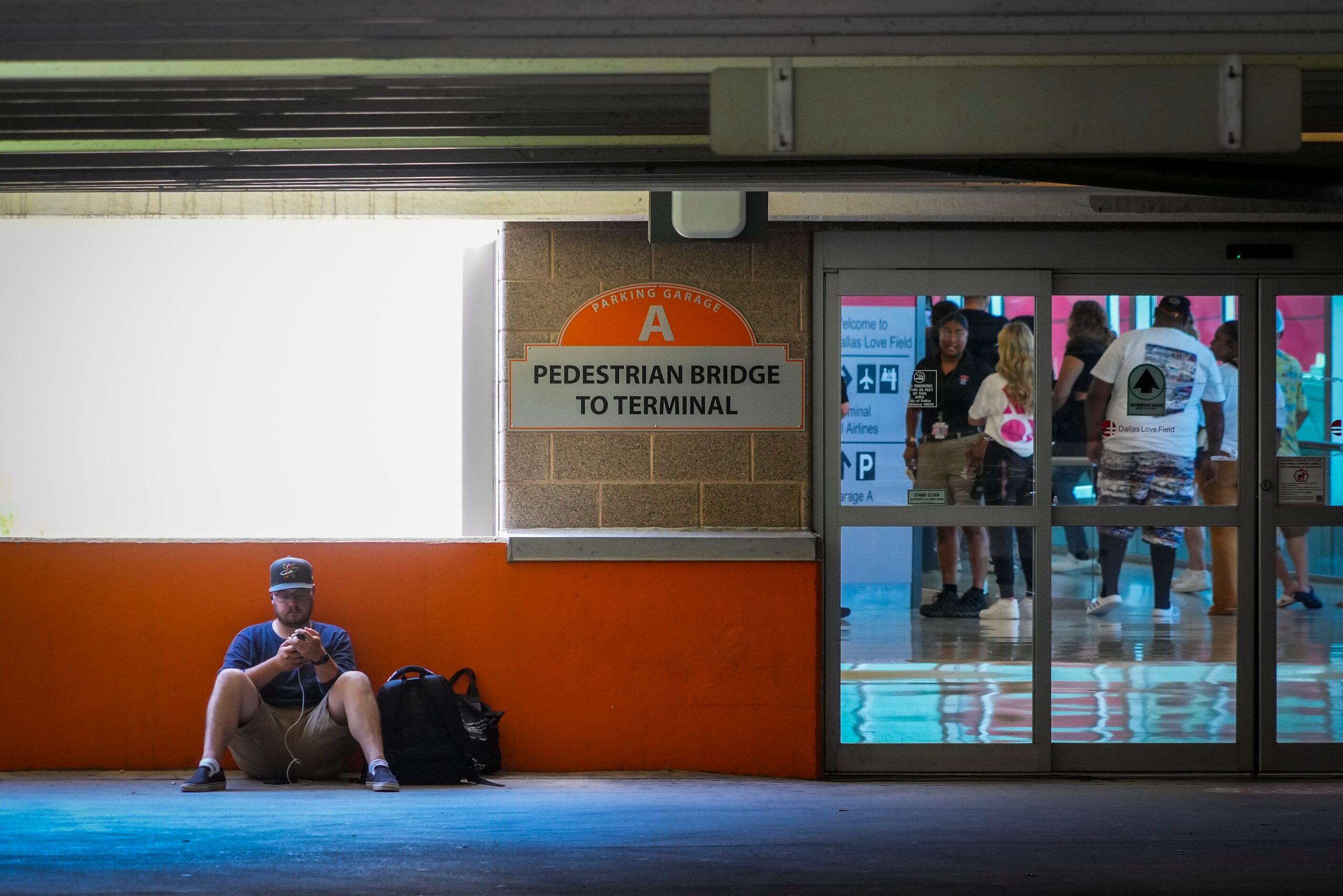 Passengers wait to reenter Dallas Love Field Airport on Monday, July 25, 2022.  A ground...