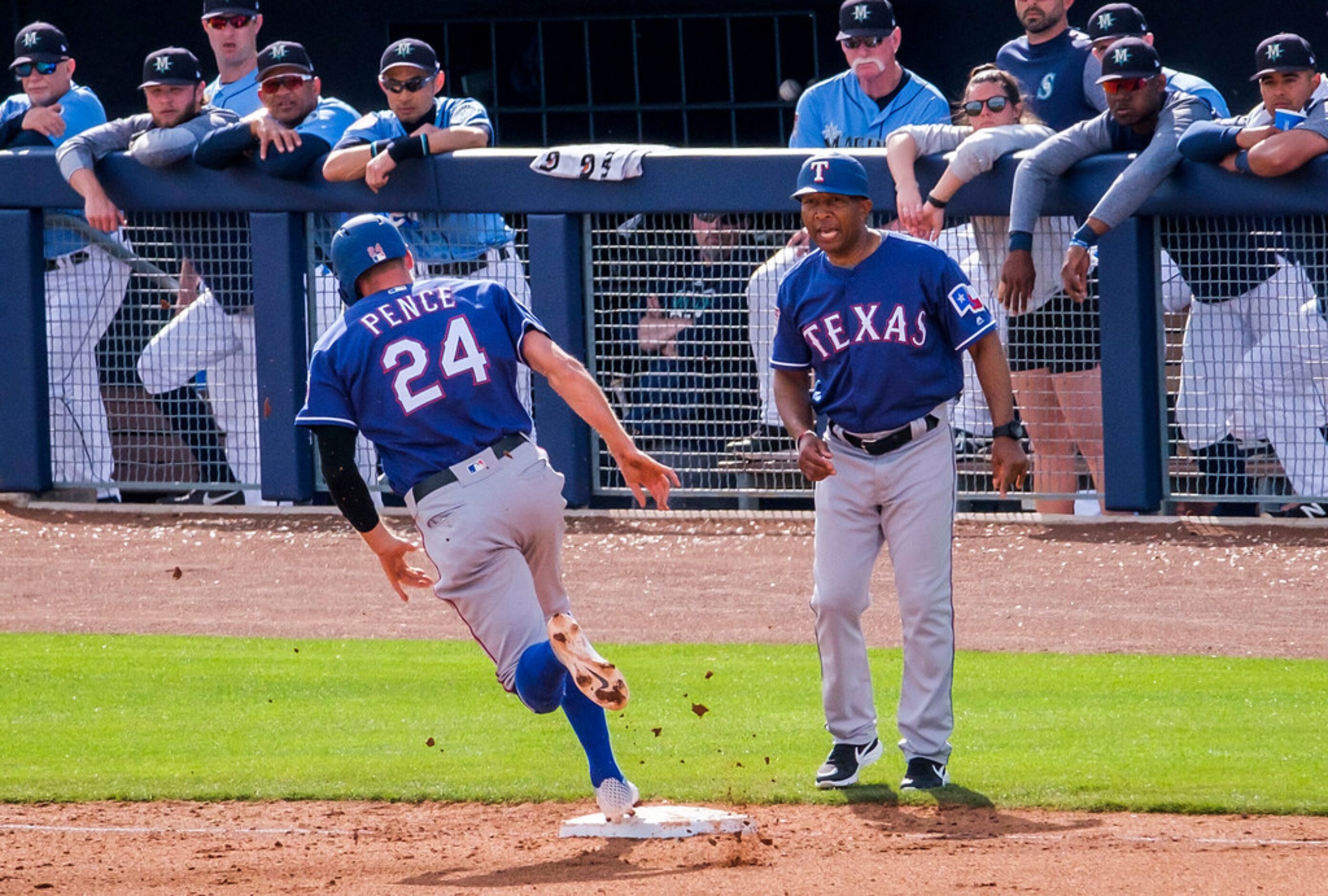 Texas Rangers third base coach Tony Beasley sends Hunter Pence home to score on a double by...