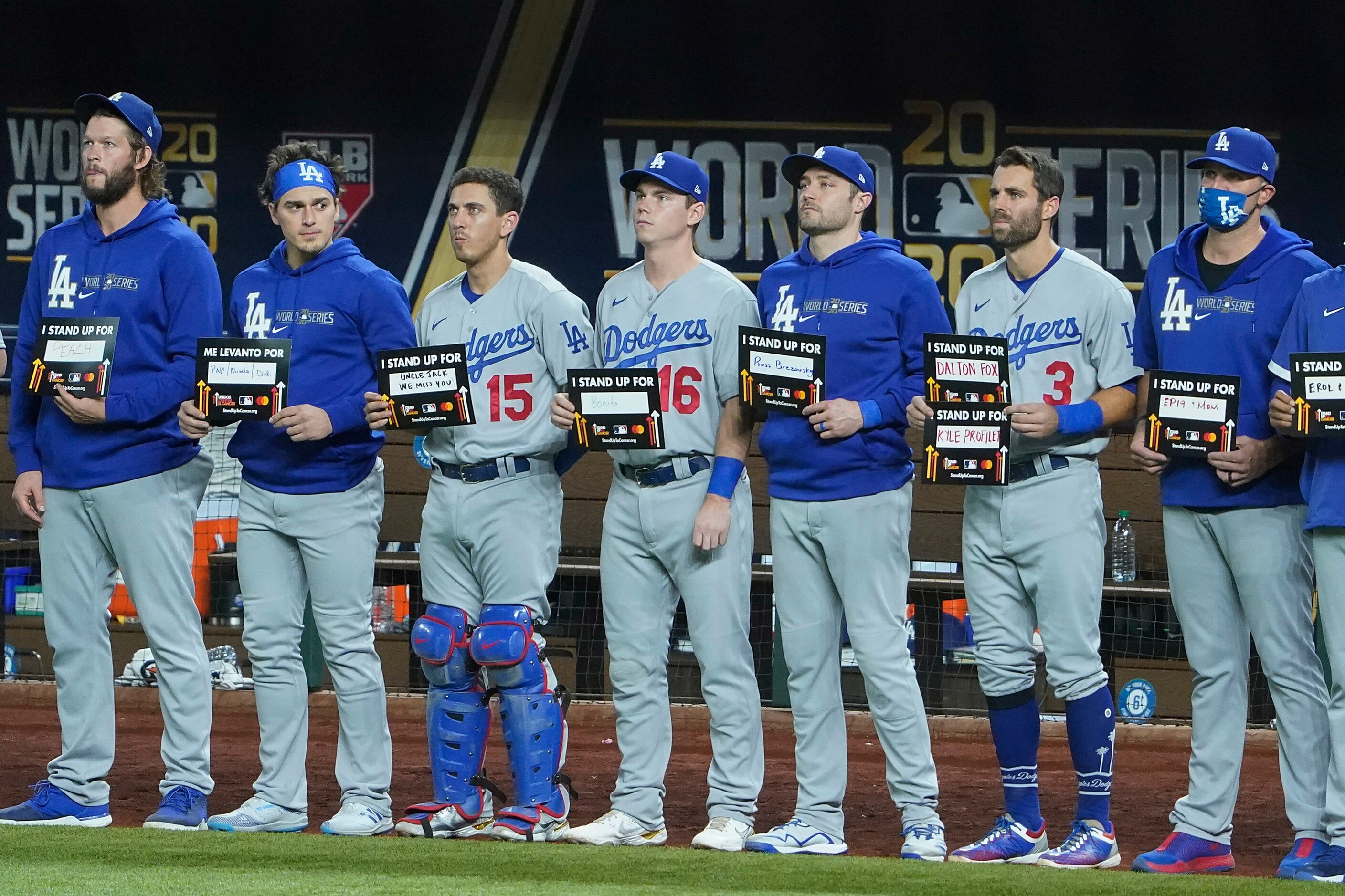 Los Angeles Dodgers players hold up signs as part of the Stand Up To Cancer campaign during...