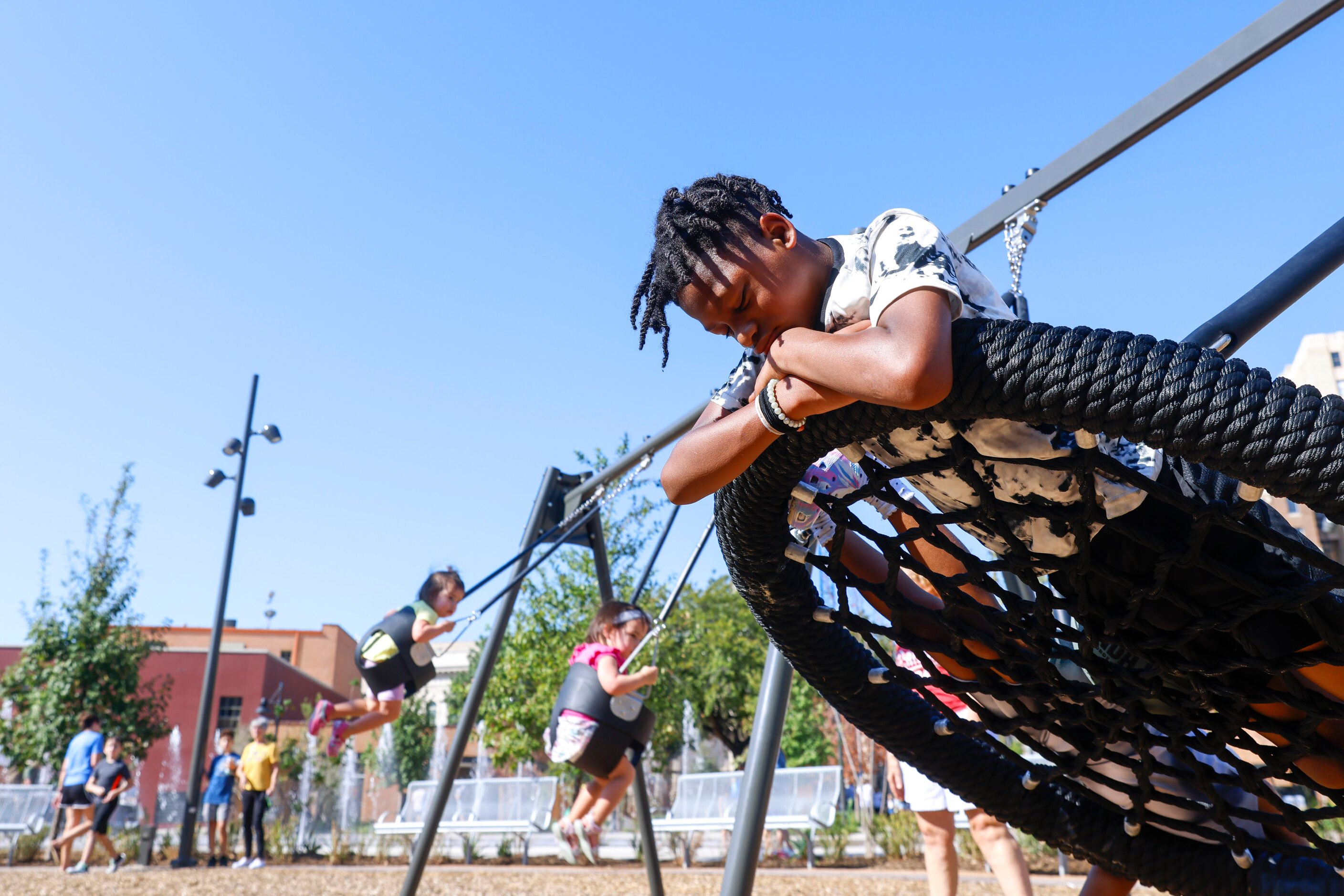 Ashton Gipson, 11, hibernates on the swing during the opening day of Harwood Park, on...