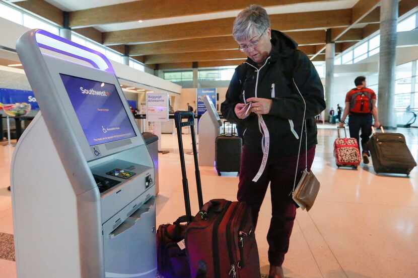 Ann Allen uses a Southwest Airlines kiosk to print some luggage tags at Dallas Love Field on...