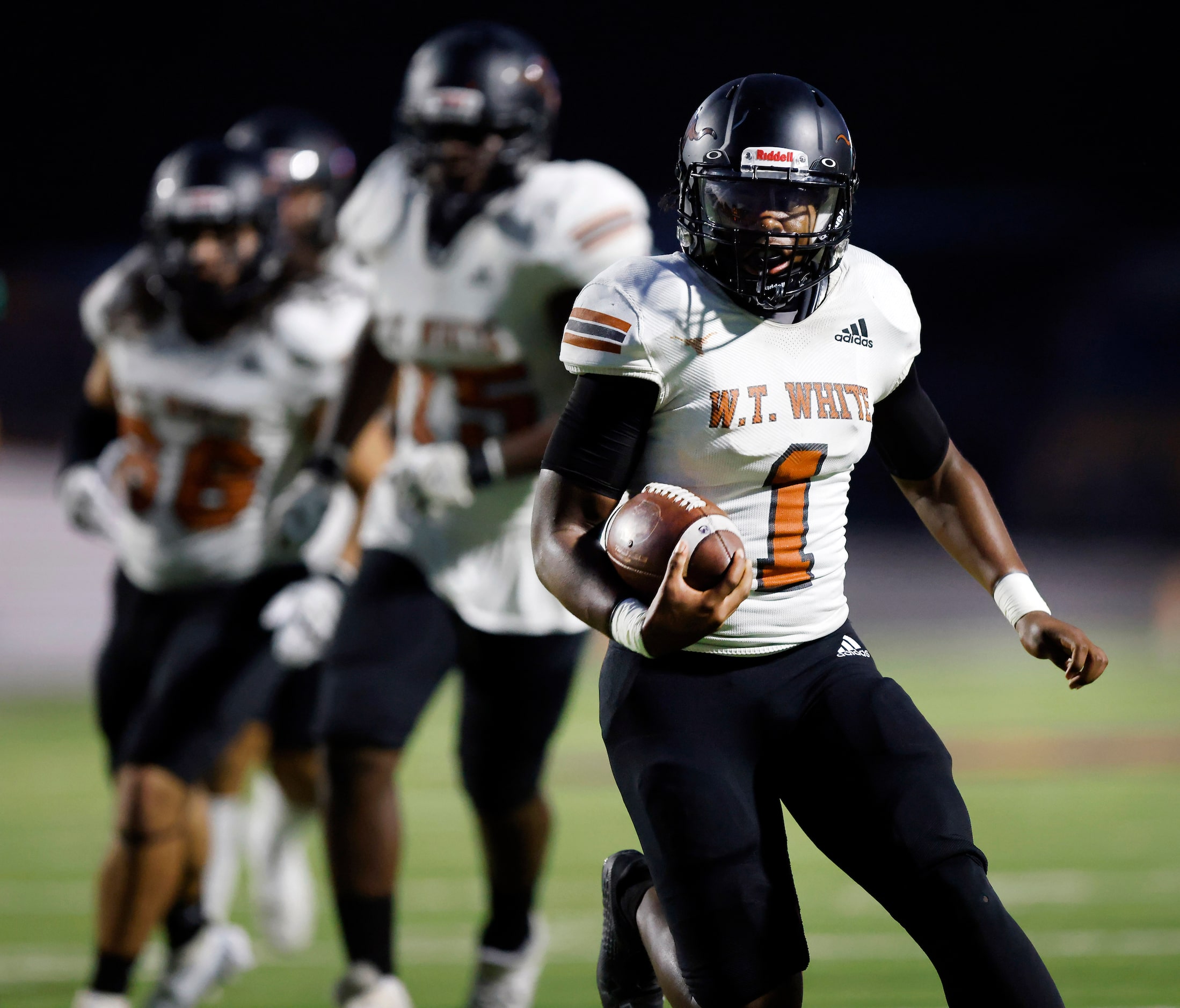 W.T. White quarterback Jaydyn Sisk (1) carries the ball as he’s pursued by the Bryan Adams...