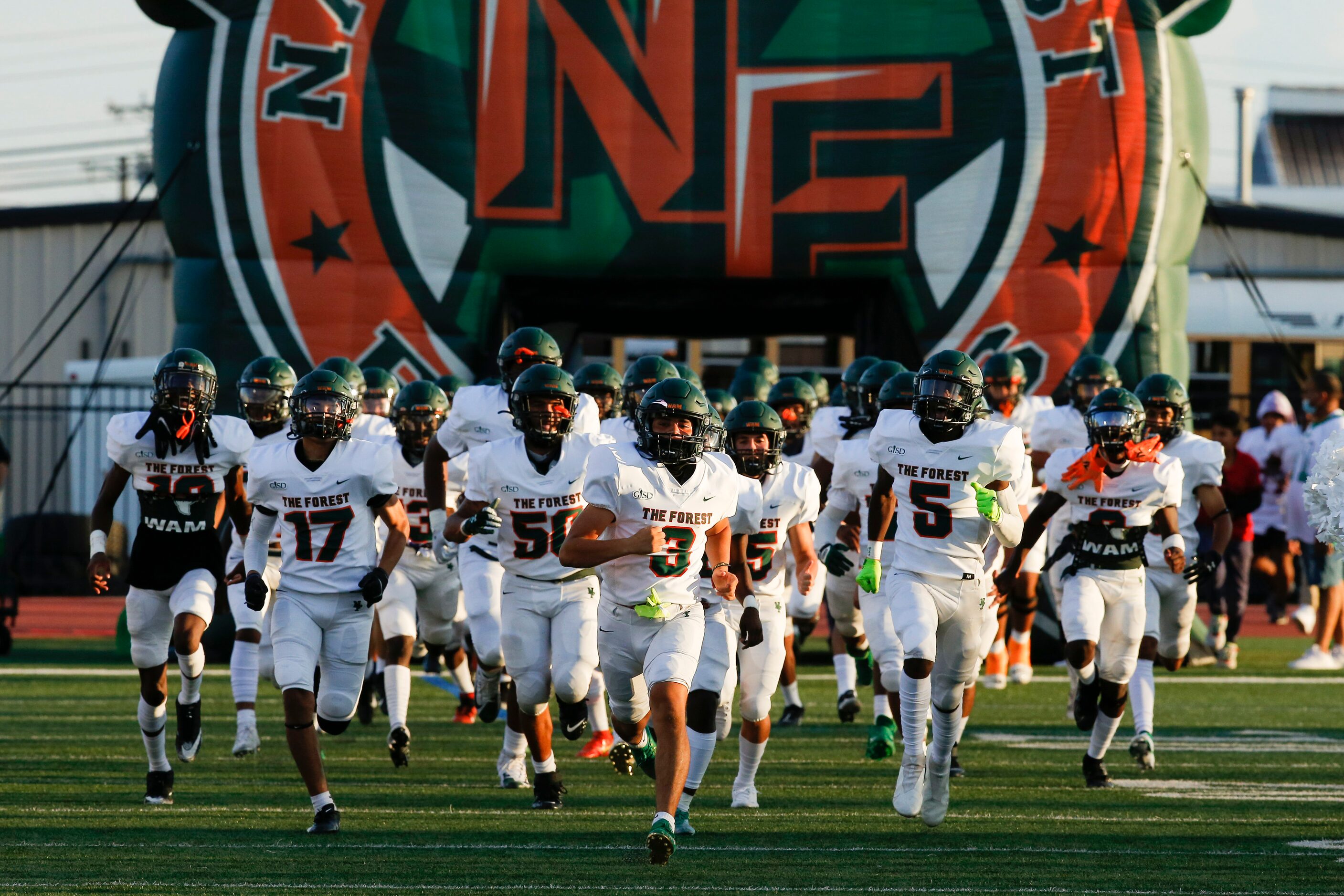 Garland Naaman Forest runs onto the field for the start of a high school football game...