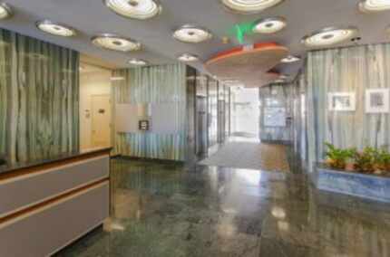  The Meadows Building's 1950s lobby has green polished stone and bubble lights in the...