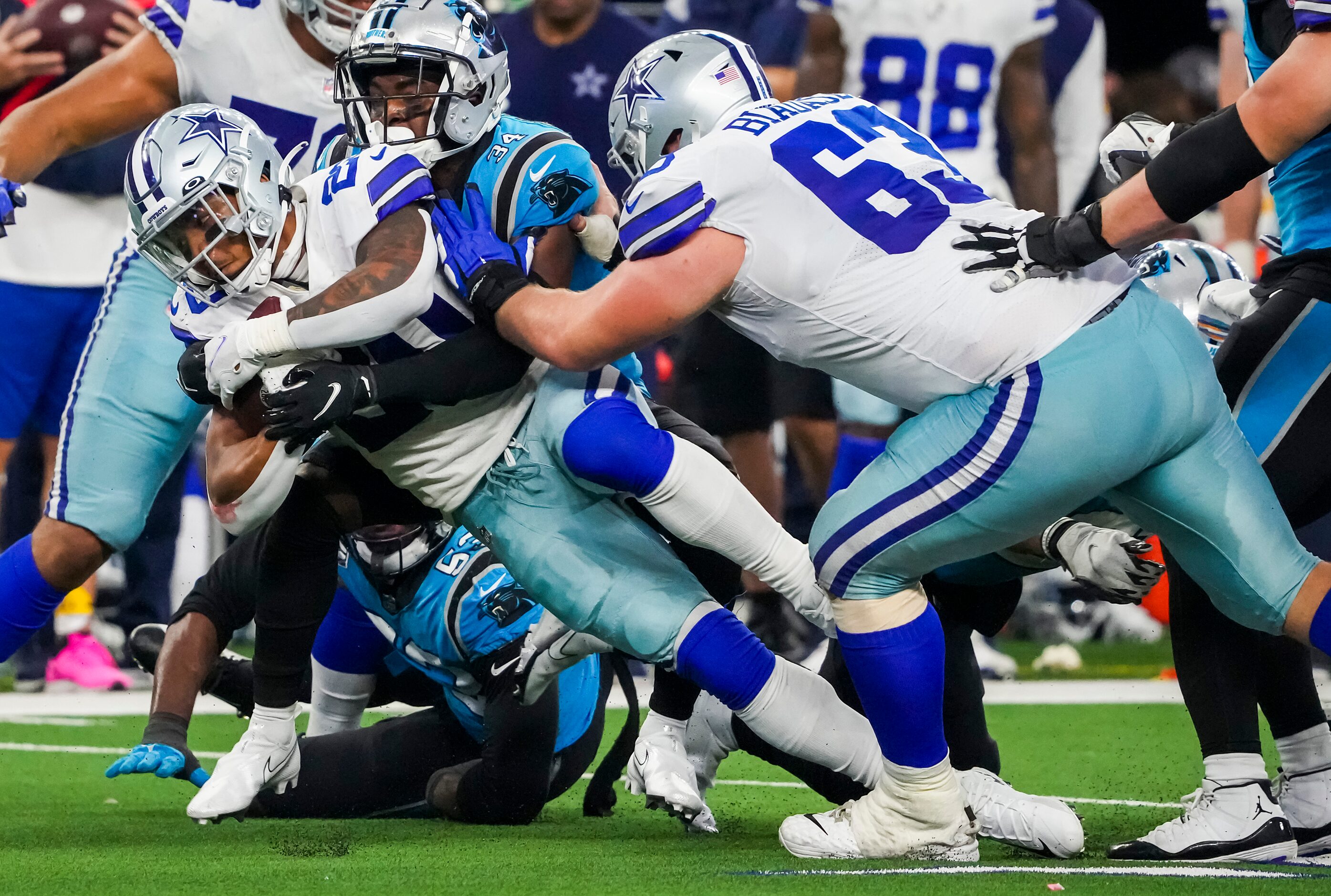 Dallas Cowboys running back Tony Pollard (20) picks up a first down as he is brought down by...