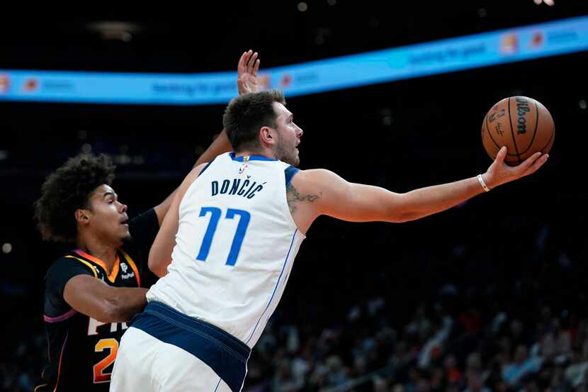Dallas Mavericks guard Luka Doncic (77) drives past Phoenix Suns forward Cameron Johnson to...