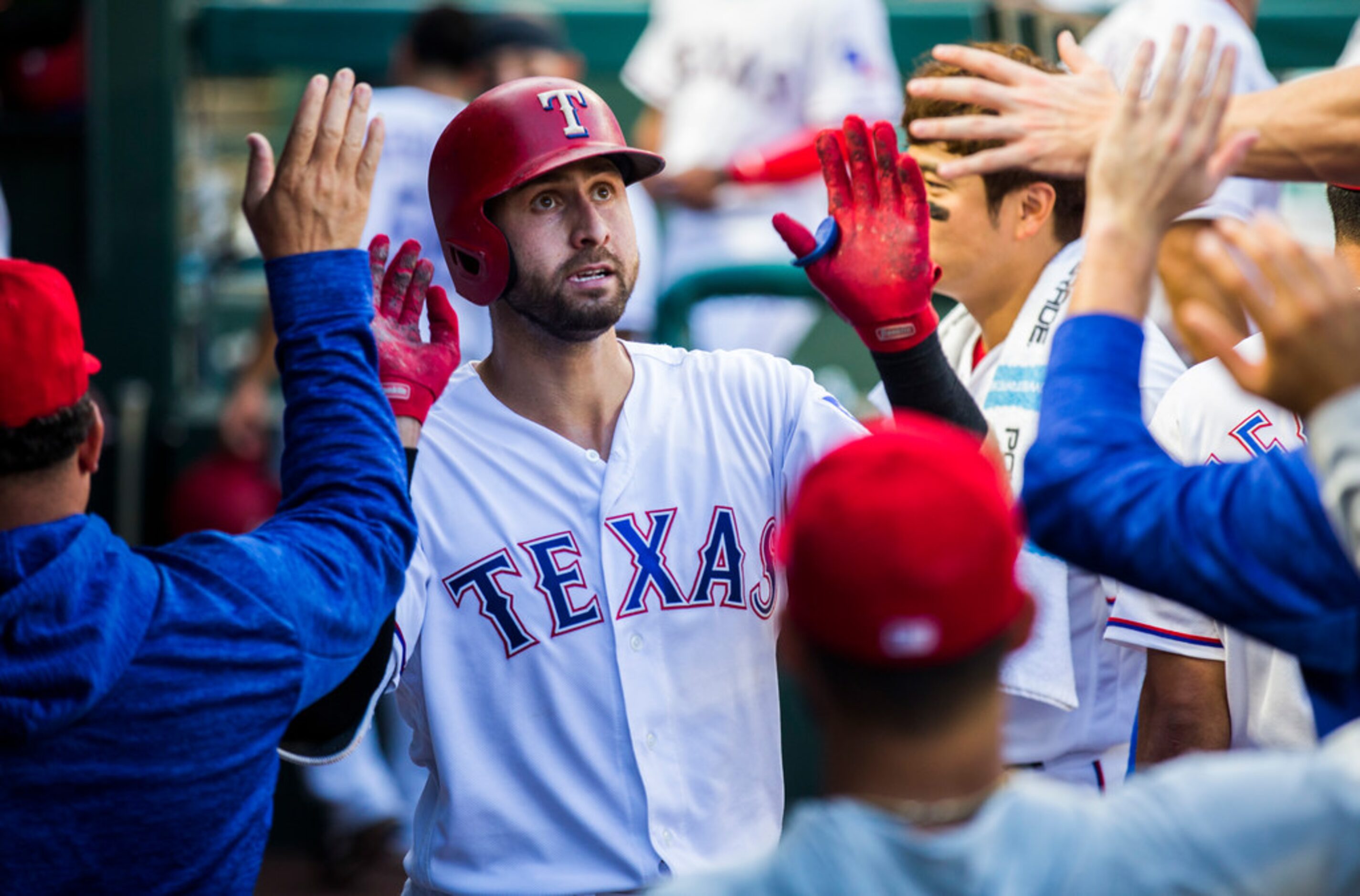 Texas Rangers second baseman Rougned Odor (12) gets high-fives in the dugout after a home...