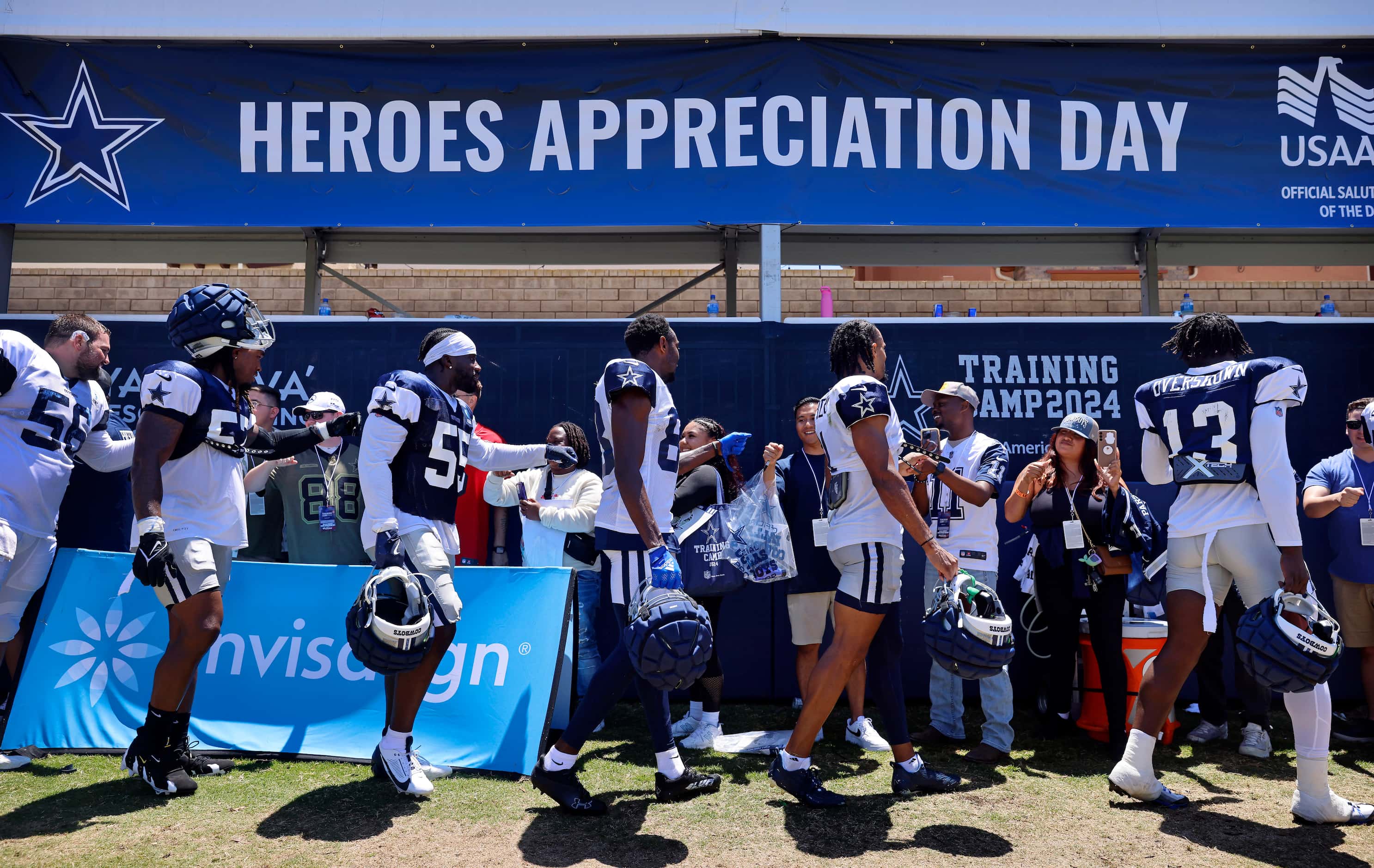 Dallas Cowboys players and coaches fist bumped military members and their families following...