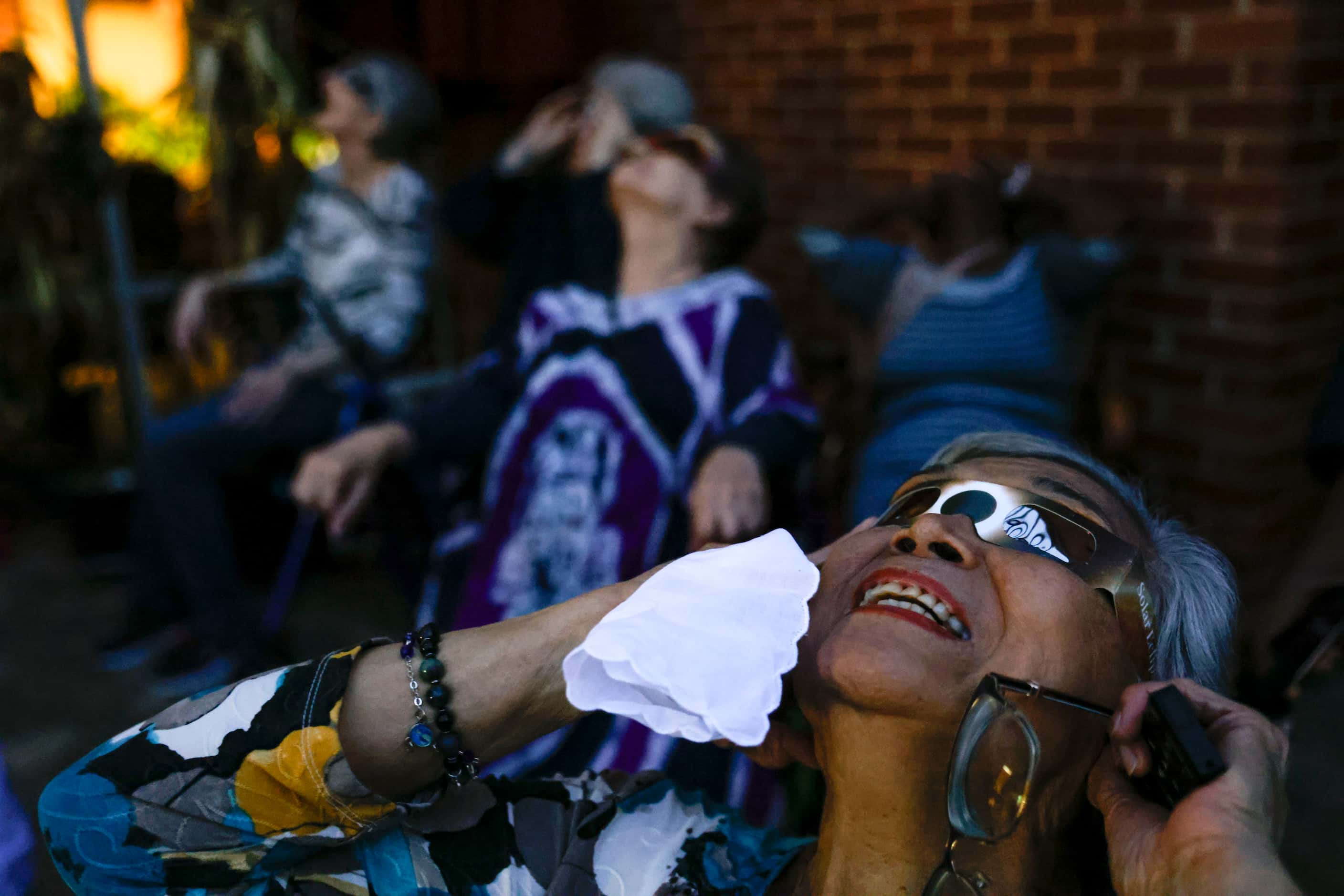 Resident Laureana P. Boado, 86, reacts as she gets a sight of the totality of the solar...