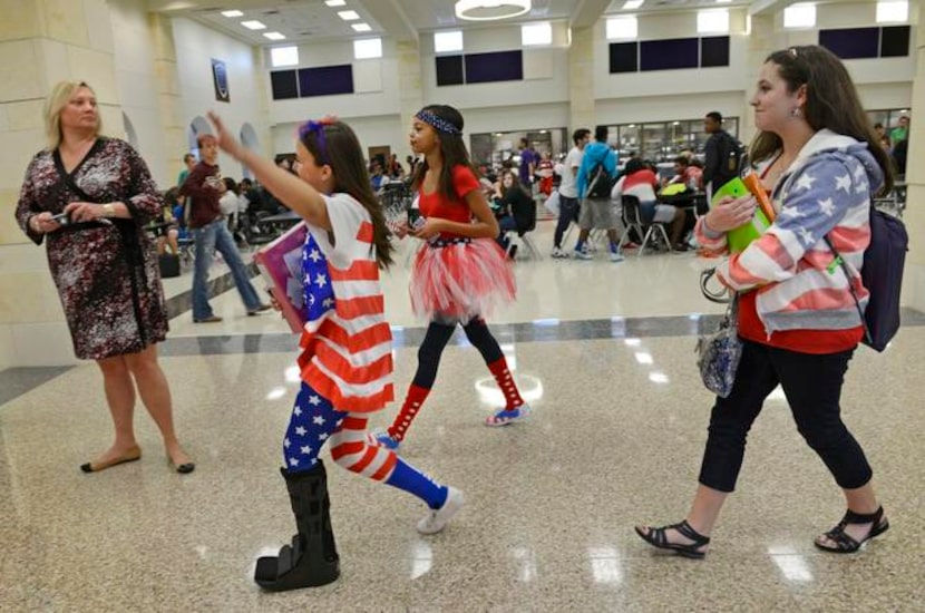 
Students Kylie Key (from left), Bri Patterson and Paige Romero walk down the hallway before...