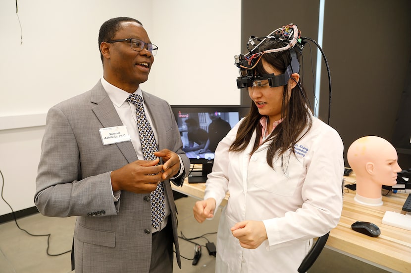 Samuel Achilefu, chairman of biomedical engineering at UT Southwestern, gets a demonstration...