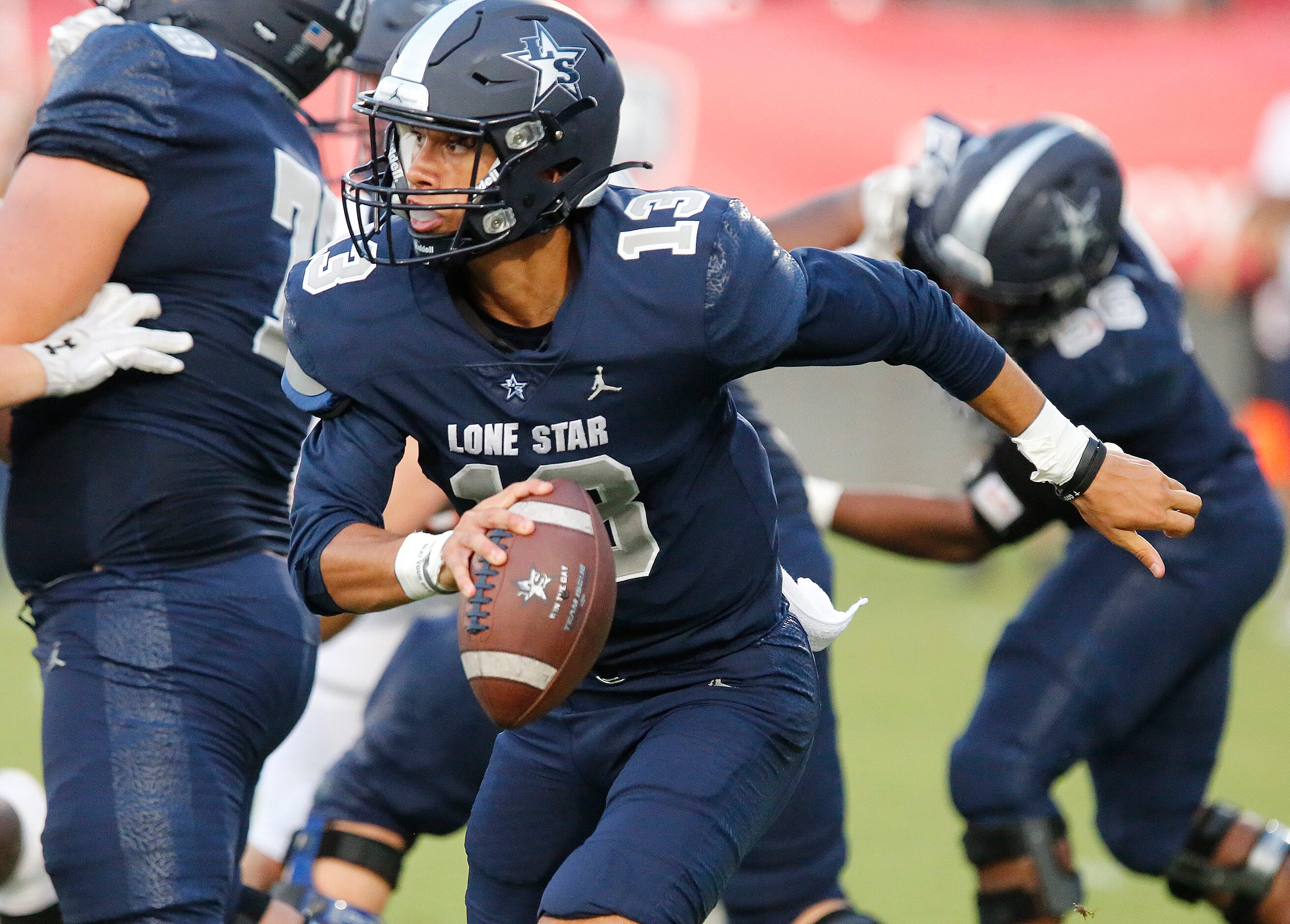 Lone Star High School quarterback Garret Rangel (13) scrambles to extend a play during the...