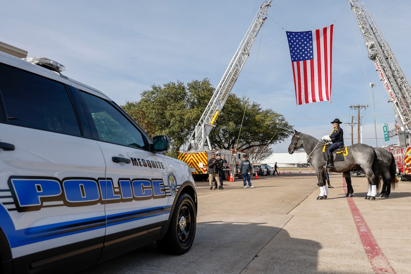 Rockwall Fire Department ladder trucks hoist an American flag outside Lake Pointe Church...