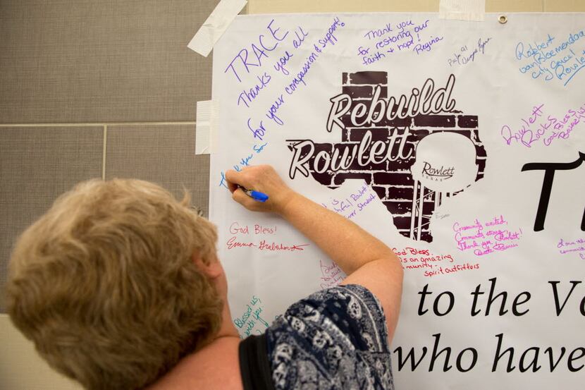 Tornado victim Sue Hartson of Rowlett wrote a message on the thank-you banner before the...