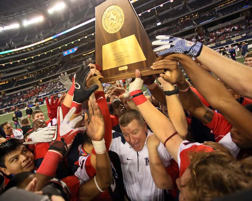 Allen head coach Tom Westerberg celebrates with his players after their 53-21 win during the...