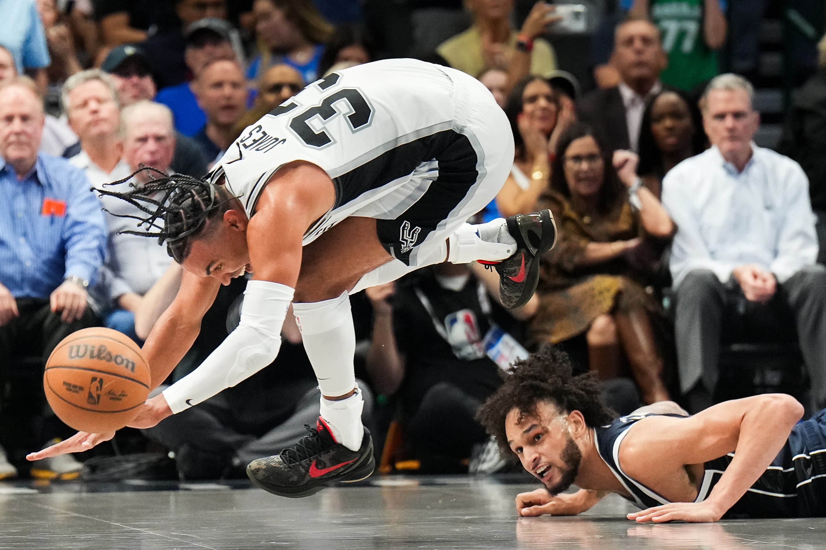 Dallas Mavericks center Dereck Lively II (2) chase a loose ball with San Antonio Spurs guard...