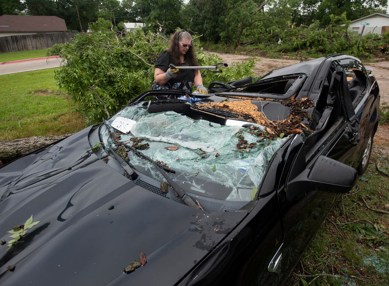 Mary Storm of Wills Point uses a grabber to pick items out of her sister's destroyed Ford...