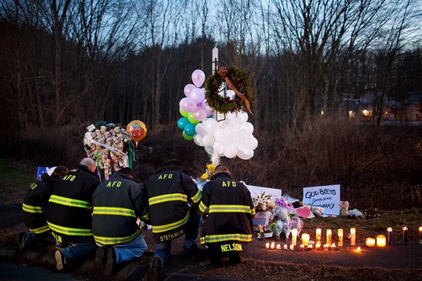 FILE -- Firefighters pay their respects to the victims of the shooting at Sandy Hook...
