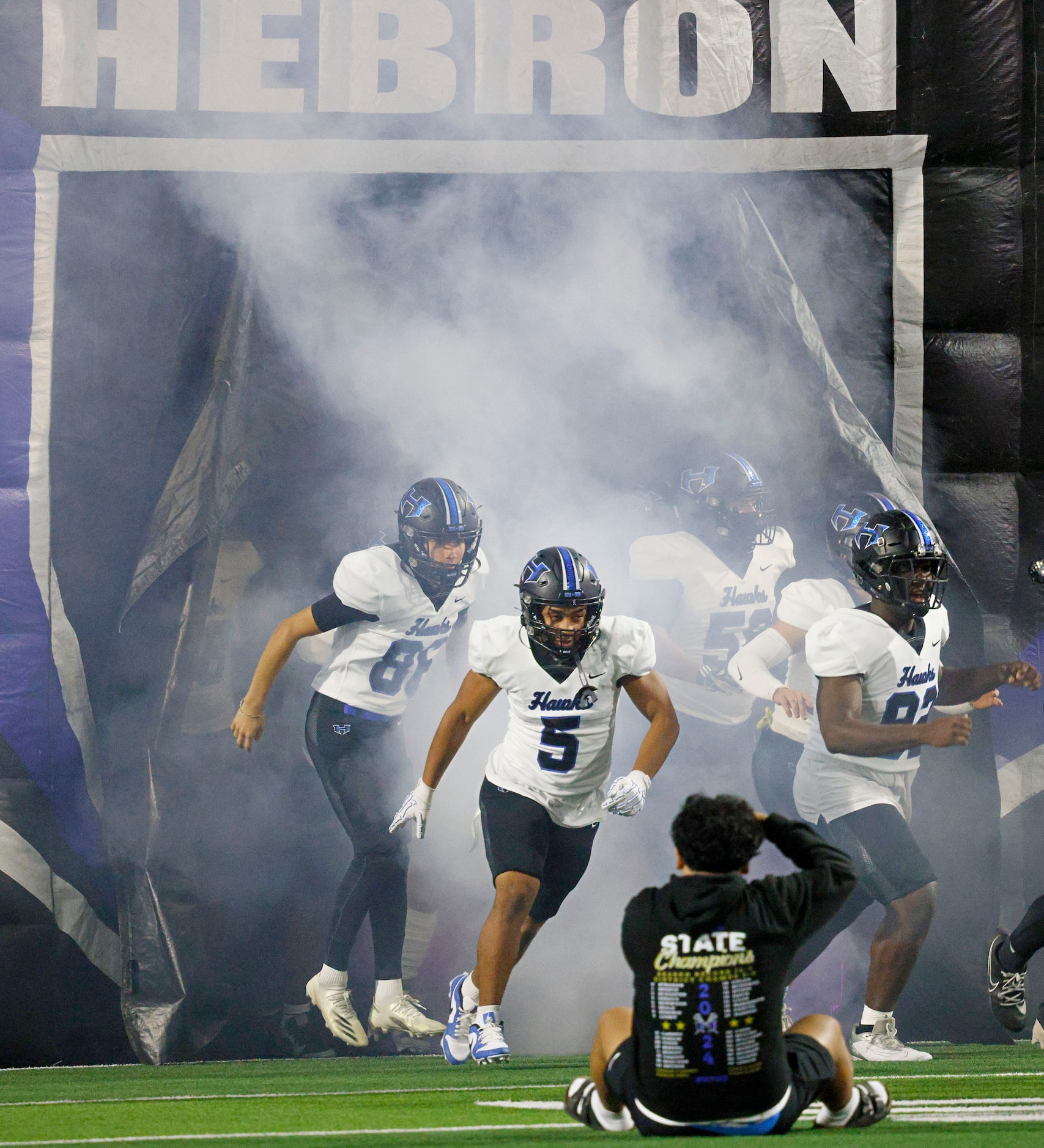 Hebron’s players run onto the field before a high school football game against Rock Hill at...